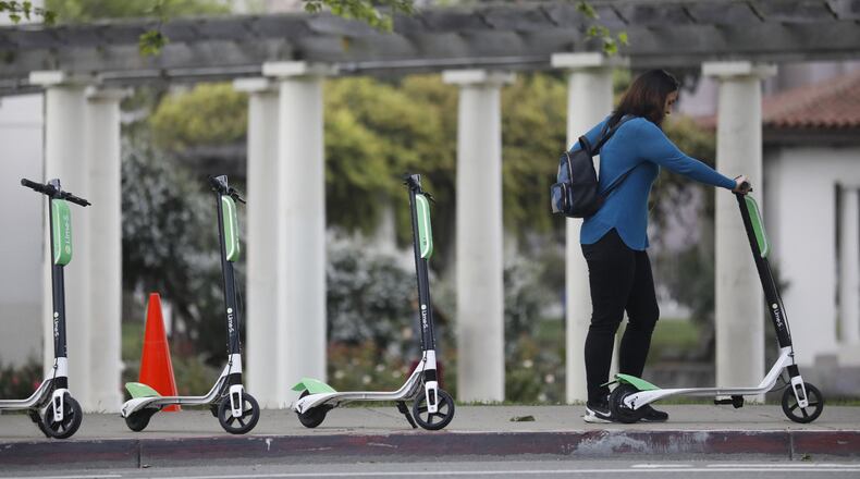 A patron uses her app to unlock a Lime-S electric scooter in Oakland, California. Even before the pandemic, electric scooter share programs had spread to more than 100 cities, including Atlanta, Los Angeles and Washington, since 2017, according to the National Association of City Transportation Officials. Total rides surged 130% to 88.5 million in 2019 from 38.5 million the year before. (Laura A. Oda/Bay Area News Group/TNS)