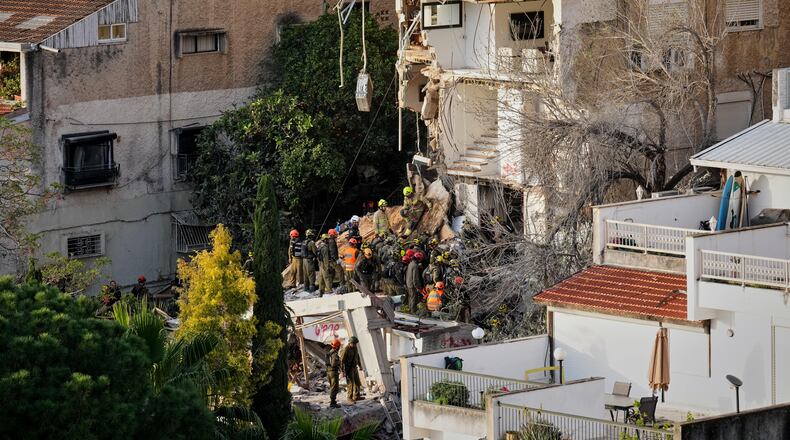 Israeli rescue teams search for missing people amid the rubble of a residential building a day after it was struck by an Iranian missile in Haifa, Israel, Monday, April 6, 2026. (AP Photo/Ariel Schalit)