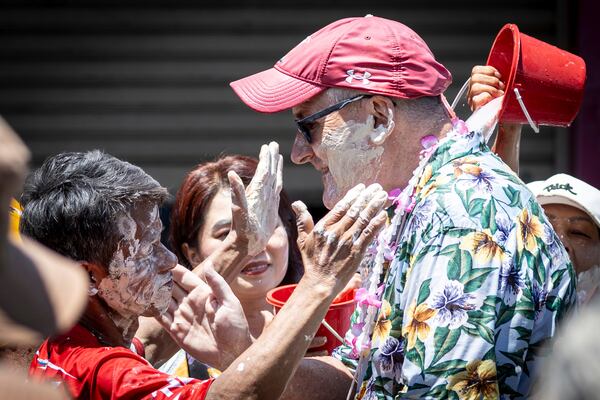 Thai people put powder on the face of a foreigner during the Songkran water festival to celebrate the Thai New Year in Prachinburi Province, Thailand, Sunday, April 13, 2025. (AP Photo/Wason Wanichakorn)