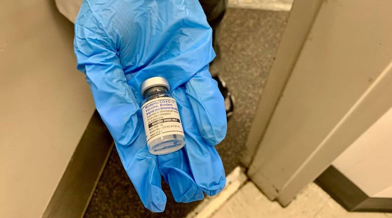 A nurse at a Walgreens pharmacy near Florida International University's Tamiami campus on 107th Avenue in Miami-Dade shows a patient the newly formulated Moderna bivalent vaccine on Sept. 7, 2022. The vaccine is an "updated booster" designed to target not only the original COVID-19 strain, but also omicron BA.4 and BA.5, which had surged in the U.S. in 2022. (Howard Cohen/Miami Herald/TNS)