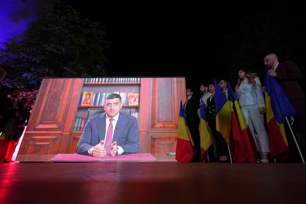 Presidential candidate George Simion is shown on a screen at the meeting of his supporters after polls closed for the first round of the country's presidential election redo in Bucharest, Romania, Sunday, May 4, 2025. (AP Photo/Andreea Alexandru)