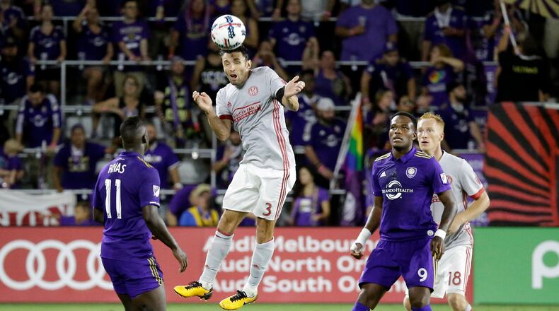 Atlanta United's Michael Parkhurst (3) heads the ball as he gets between Orlando City's Carlos Rivas (11) and Cyle Larin (9) during the second half of an MLS soccer match, Friday, July 21, 2017, in Orlando, Fla. Atlanta United won 1-0. (AP Photo/John Raoux)