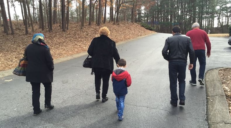 Jim and Jeanne Slaughenhoup, volunteers with Johnson Ferry Baptist Church in Marietta, lead Hasan and his parents, Mohammad and Ebtesam, to the school Hasan will be attending in this 2015 file photo. Jeremy Redmon,jredmon@ajc.com