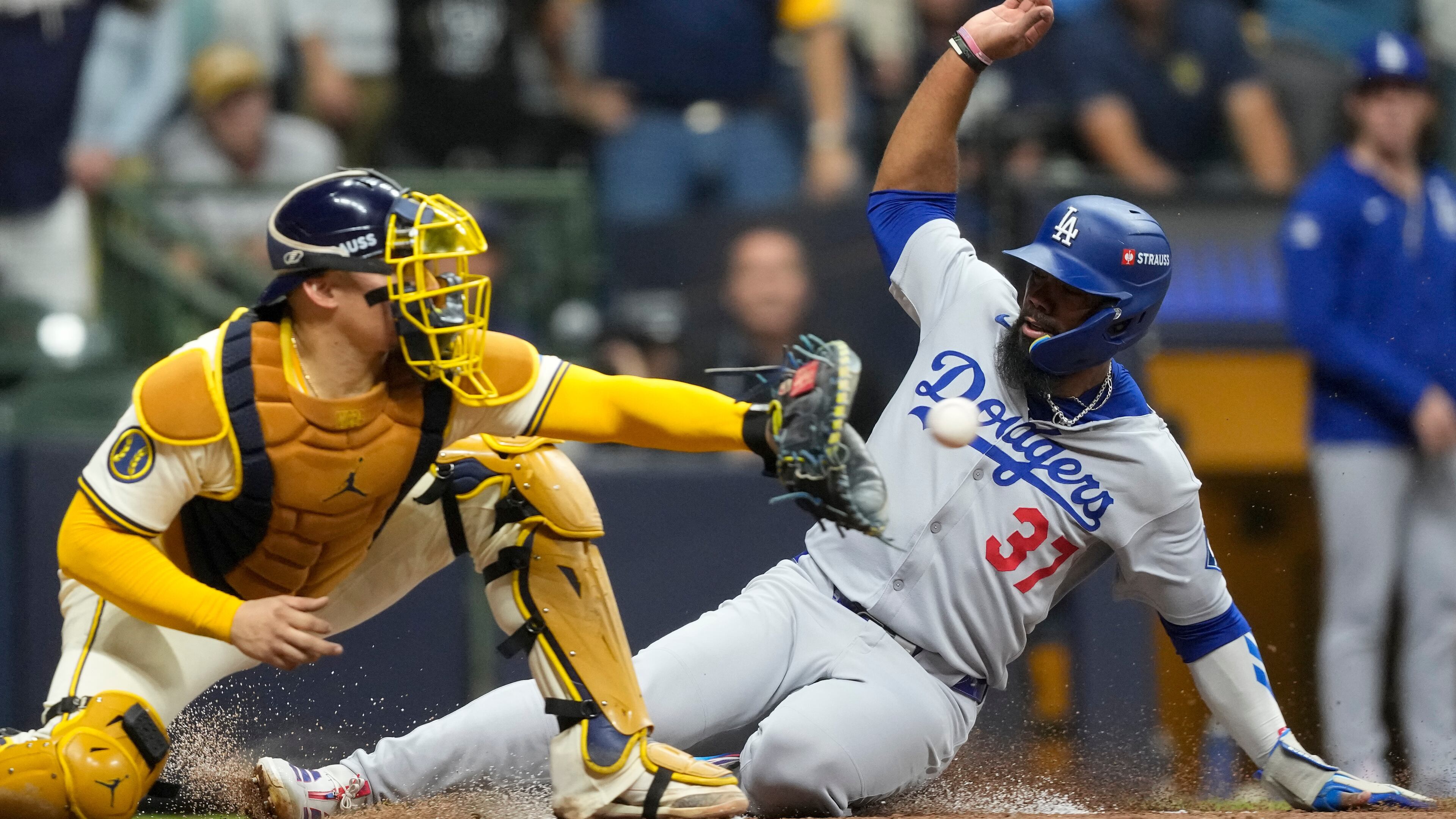 Los Angeles Dodgers' Teoscar Hernández is forced out at home by Milwaukee Brewers catcher William Contreras during the fourth inning in Game 1 of baseball's National League Championship Series, Monday, Oct. 13, 2025, in Milwaukee. (AP Photo/Brynn Anderson)
