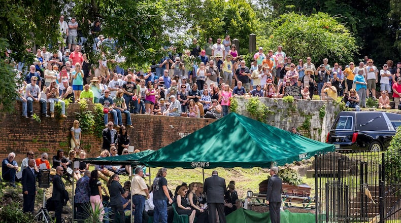 Family, friends and fans attend Gregg Allman's burial at Rose Hill Cemetery, Saturday, June 3, 2017, in Macon, Ga. The family hopes to modify the area and remove the fence separating Gregg from his brother Duane and bandmate Berry Oakley. (AP Photo/Branden Camp)