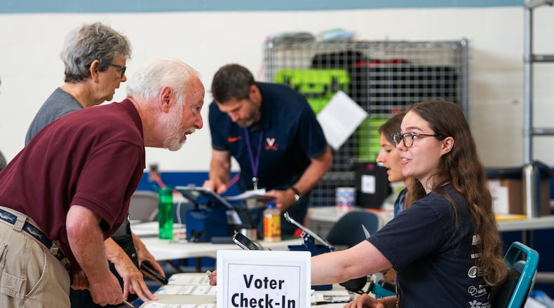 Voters check in at Lyles-Crouch Traditional Academy for the Virginia primary election, Tuesday, Aug. 4, 2026, in Alexandria, Va. (AP Photo/Allison Robbert)