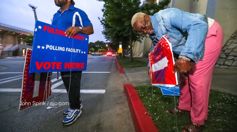 Poll workers Chris Nolan (left) and Raphallia Edwards set up outside Grady High School.