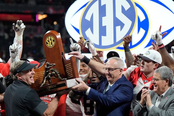Georgia head coach Kirby Smart receives the SEC championship trophy from conference Commissioner Greg Sankey. (Mike Stewart/AP)