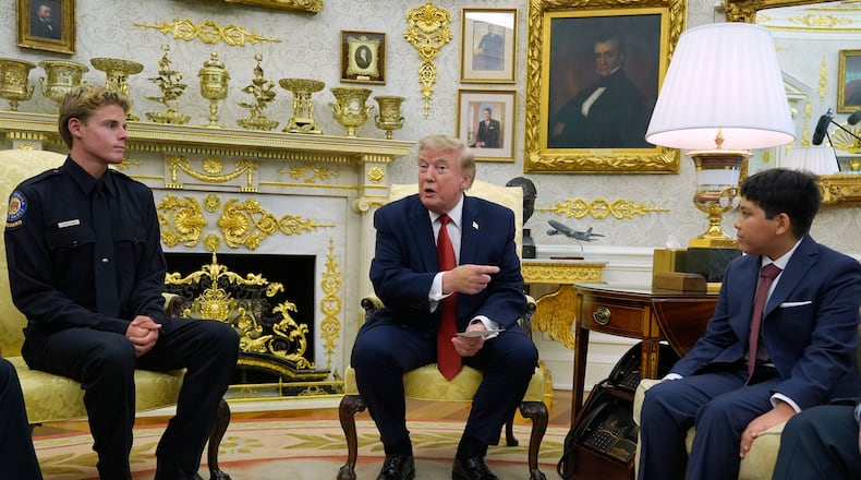 President Donald Trump gestures to Nathaniel Rai, the boy lifeguard Ryder Williams, left, saved as they meet in the Oval Office of the White House, Monday, Aug. 17, 2026, in Washington. (AP Photo/Manuel Balce Ceneta)