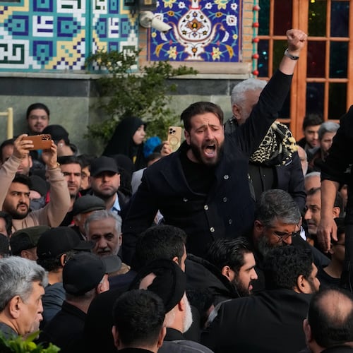A man chants slogan while the body of Gen. Ali Shamkhani, secretary of Iran's Defense Council and a senior adviser to the Supreme Leader who was killed in a strike, is being buried at the courtyard of the Imamzadeh Saleh shrine in Tehran, Iran, Saturday, March 14, 2026. (AP Photo/Vahid Salemi)