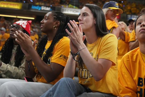 Indian Fever basketball players Caitlin Clark, right, and Aliyah Boston watch during the first half of Game 3 of the NBA Finals basketball series between the Indiana Pacers and the Oklahoma City Thunder, Wednesday, June 11, 2025, in Indianapolis. (AP Photo/Michael Conroy)