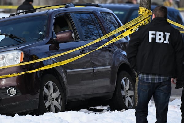 A bullet hole is seen in the windshield as law enforcement officers attend to the scene of the shooting involving federal law enforcement agents, Wednesday, Jan. 7, 2026, in Minneapolis. (Tom Baker/AP)