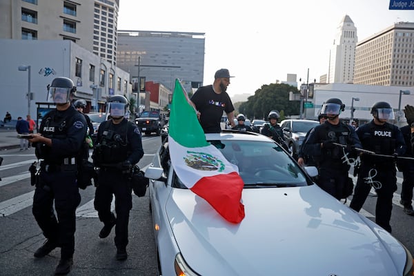 Protesters rally during a protest in response to a series of United States Immigration and Customs Enforcement (ICE) raids, in Los Angeles, on Monday, June 9, 2025. (Stephen Lam/San Francisco Chronicle via AP)