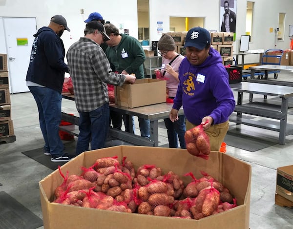 Volunteers pack produce at the Alameda County Community Food Bank in Alameda, Calif., on Friday, April 25, 2025. (AP Photo/Terry Chea)