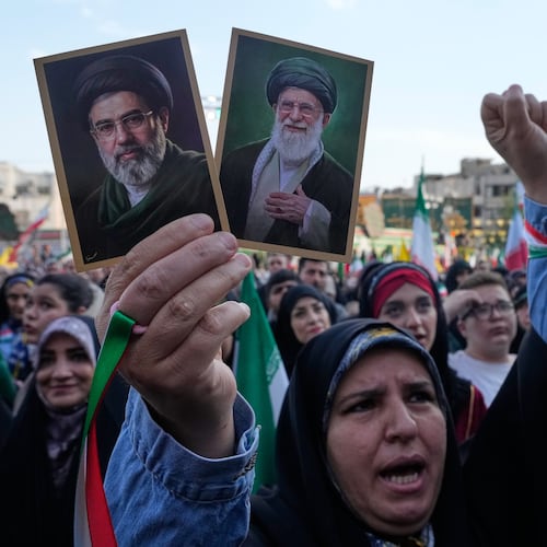 A woman holds up pictures of the Iranian Supreme Leader Ayatollah Mojtaba Khamenei, left, and his father, the slain Ayatollah Ali Khamenei in a state-organised rally celebrating the birthday of Imam Reza, the 8th Shiite Muslims' Imam, and supporting the supreme leader, in Tehran, Iran, Wednesday, April 29, 2026. (AP Photo/Vahid Salemi)