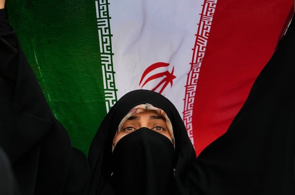 An Iranian woman holds up her country's flag in an anti-U.S. and anti-Israeli rally at Enqelab-e-Eslami (Islamic Revolution) square in downtown Tehran, Iran, Tuesday, June 24, 2025. (AP Photo/Vahid Salemi)