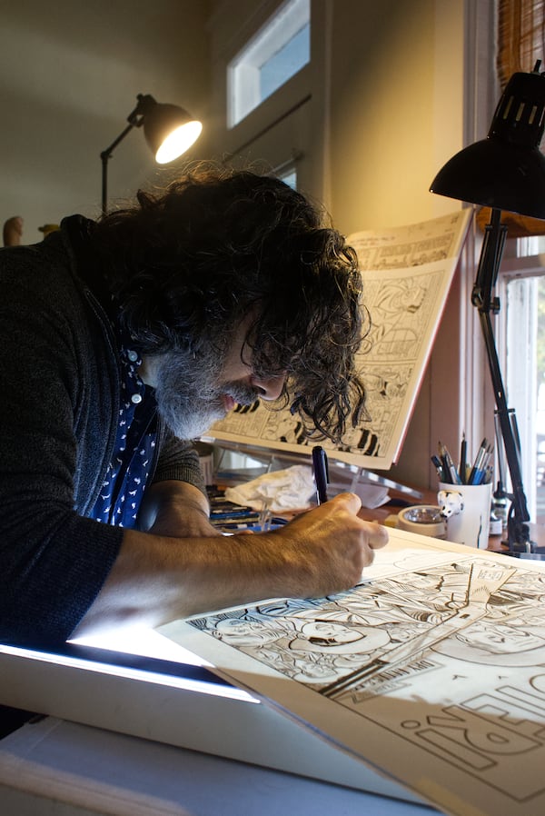 Tommaso illustrates the old-fashioned way, starting with small concept sketches, enlarging to detailed pencil drawings, then tracing and hand lettering with ink. (Dustin Timbrook/Courtesy of Arts ATL)
