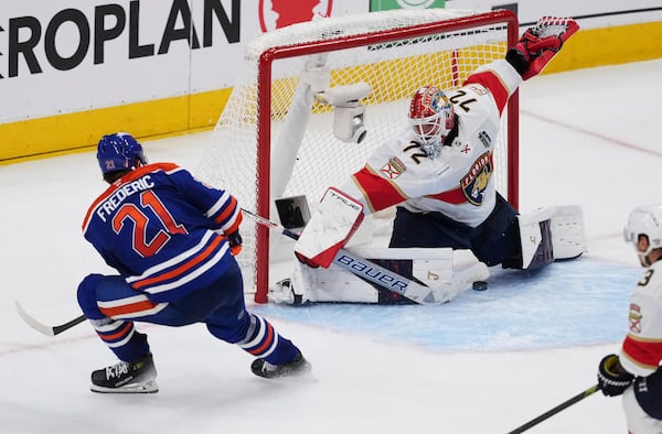 Florida Panthers goalie Sergei Bobrovsky (72) stops Edmonton Oilers' Trent Frederic (21) during the first overtime period in Game 1 of the NHL Stanley Cup Final, in Edmonton, Alberta, on Wednesday, June 4, 2025. (Darryl Dyck/The Canadian Press via AP)