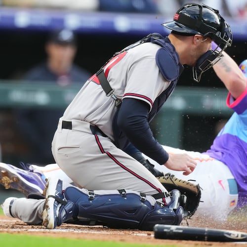 Atlanta Braves catcher Jonah Heim, front, tries to field the throw as Colorado Rockies' TJ Rumfield scores on a ground out by Willi Castro in the first inning of a baseball game Friday, May 1, 2026, in Denver. (AP Photo/David Zalubowski)