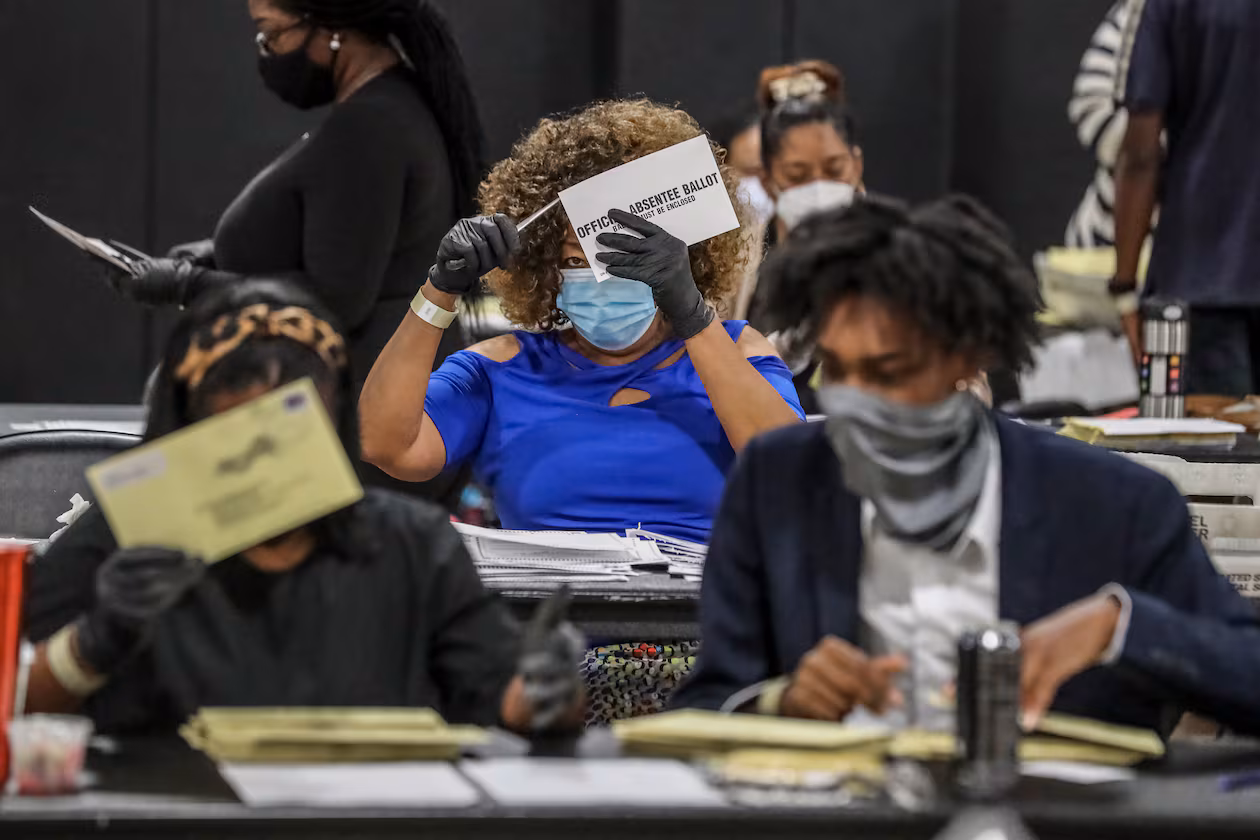 Fulton County Registration & Elections Board workers handle absentee ballots in August 2020. Two lawyers who represented Georgia Republicans in election cases are now working for the U.S. Department of Justice and have filed lawsuits to obtain Fulton's 2020 election records and Georgia's unredacted voter rolls. (John Spink/AJC 2020)