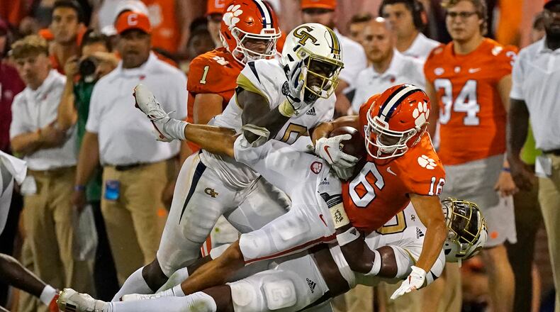 Clemson wide receiver E.J. Williams is brought down by Georgia Tech's Ayinde Eley (10) and Tariq Carpenter after a catch in the second half of a college football game in September 2021. For the second consecutive year, the preseason media poll conducted by the ACC projects the Yellow Jackets to finish sixth in the Coastal Division. (AP Photo/John Bazemore)