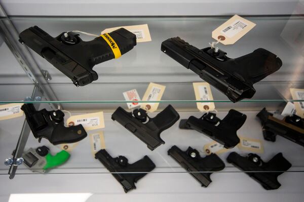 Handguns are displayed inside a gun store.