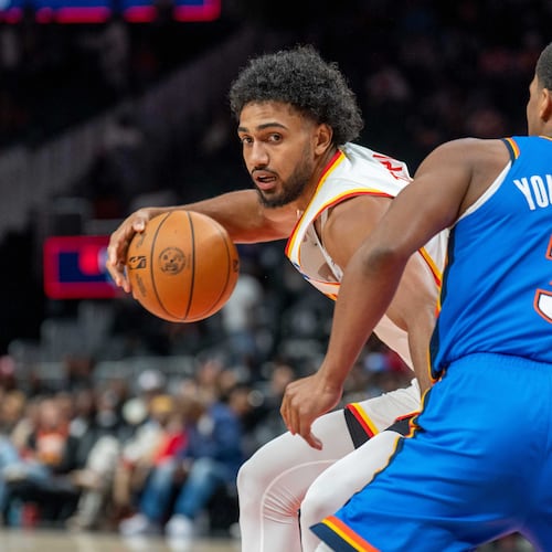 Atlanta Hawks forward Jacob Toppin, left, drives the ball against Oklahoma City Thunder guard Chris Youngblood (3) during the first half of an NBA basketball game, Saturday, Oct. 25, 2025, in Atlanta. (AP Photo/Erik Rank)