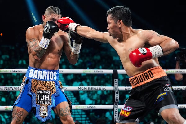 Mario Barrios, left, fights Manny Pacquiao in a welterweight title boxing match Saturday, July 19, 2025, in Las Vegas. (AP Photo/John Locher)