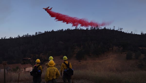 FILE - U,S. Forest Service firefighters from Stonyford, Calif., from left, Vivian Perez, Emma Nieforth, Jonny Connelly and Nick Bonnie watch as a BAe-146 air tanker is used to go indirect on the Ridge Fire, as a secondary contingency line, July 20, 2024, east of Clearlake, Calif. (Kent Porter/The Press Democrat via AP, File)