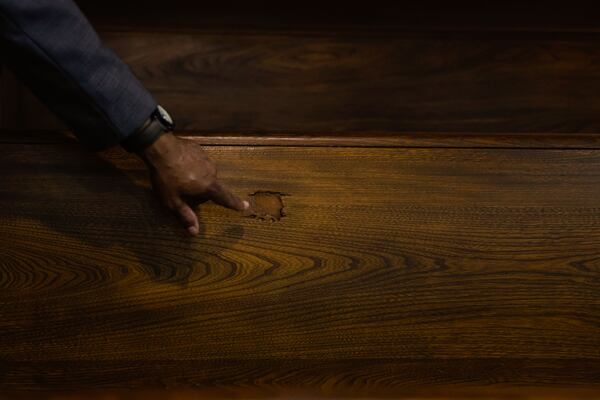Derek King points to a pew pierced by a bullet at Ebenezer Baptist Church. The bullet hole is a physical reminder of the deadly shooting that took the life of Alberta King and 69-year-old deacon Edward Boykin in 1974. (Natrice Miller/ AJC)