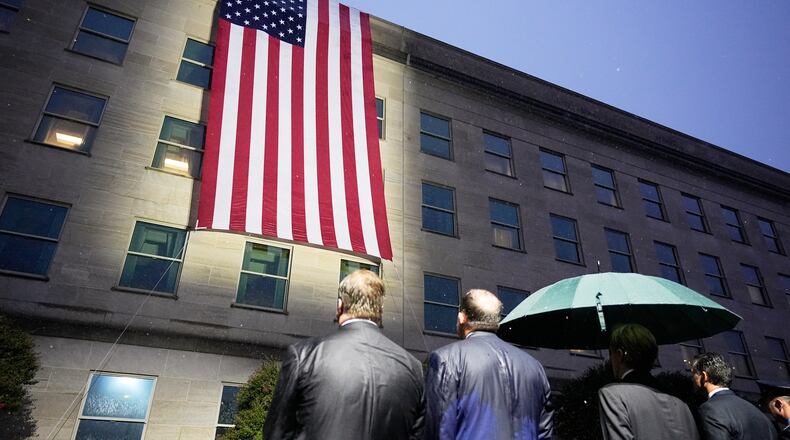 Secretary of Defense Pete Hegseth, Chairman of the Joint Chiefs, Air Force Gen. Dan Caine, and other officials, watch as the flag is unfurled at the Pentagon, Friday, Sept. 11, 2026 in Arlington, Va. (AP Photo/Manuel Balce Ceneta)