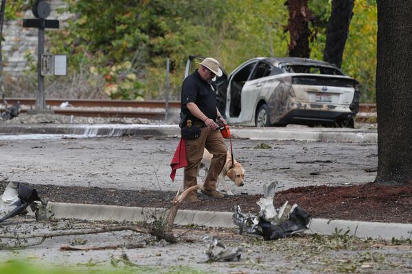 Emergency personnel respond to the area where a small plane crashed on the railroad tracks beneath the overpass near Interstate 95 in Boca Raton, Fla., on Friday, April 11, 2025. (AP Photo/Marta Lavandier)