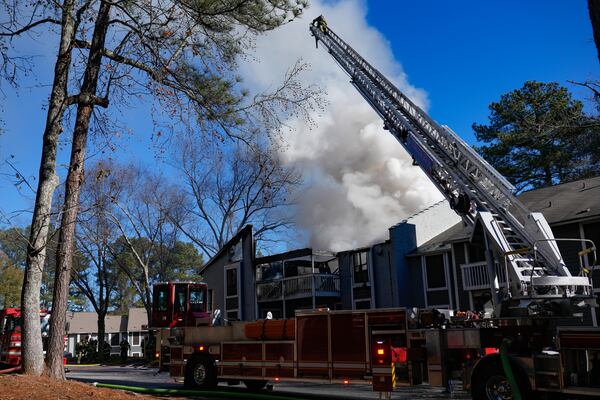 Heavy smoke pours from an apartment building as DeKalb County firefighters battle a large blaze Monday. (Ben Hendren for the AJC)