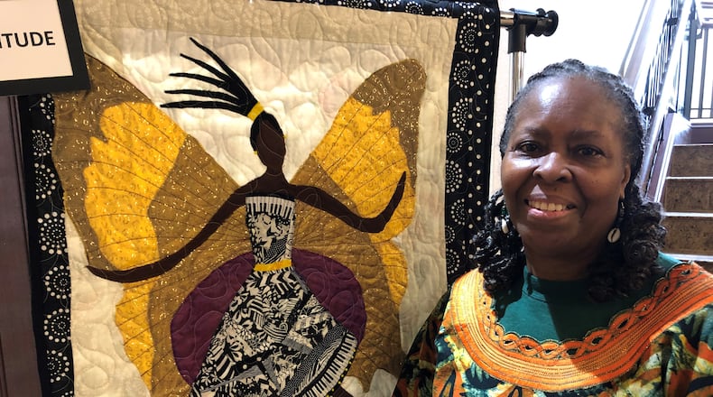 Master quilter Aisha Lumumba with one of her two quilts at Stockbridge City Hall.