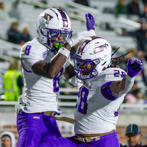 James Madison wide receiver Isaiah Alston (8) celebrates with running back Jobi Malary, right, after catching a touchdown pass against Coastal Carolina during the second half of an NCAA college football game in Conway, S.C., Saturday, Nov. 29, 2025. (AP Photo/Nell Redmond)