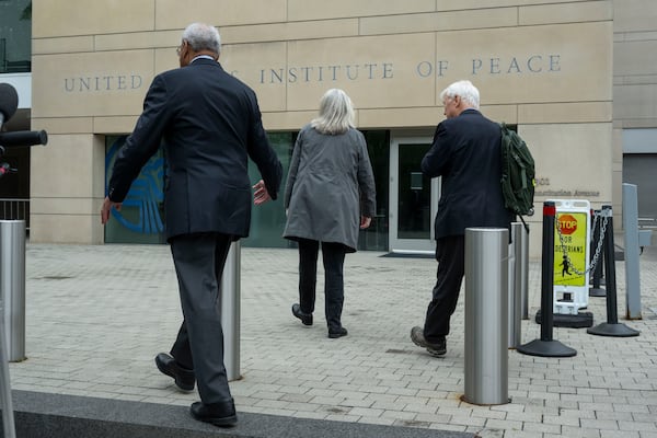 U.S. Institute of Peace (USIP) acting President George Moose, left, and USIP acting counsel George Foote, right, walk back into the Institute following a news conference, Wednesday, May 21, 2025 in Washington. (AP Photo/Kevin Wolf)