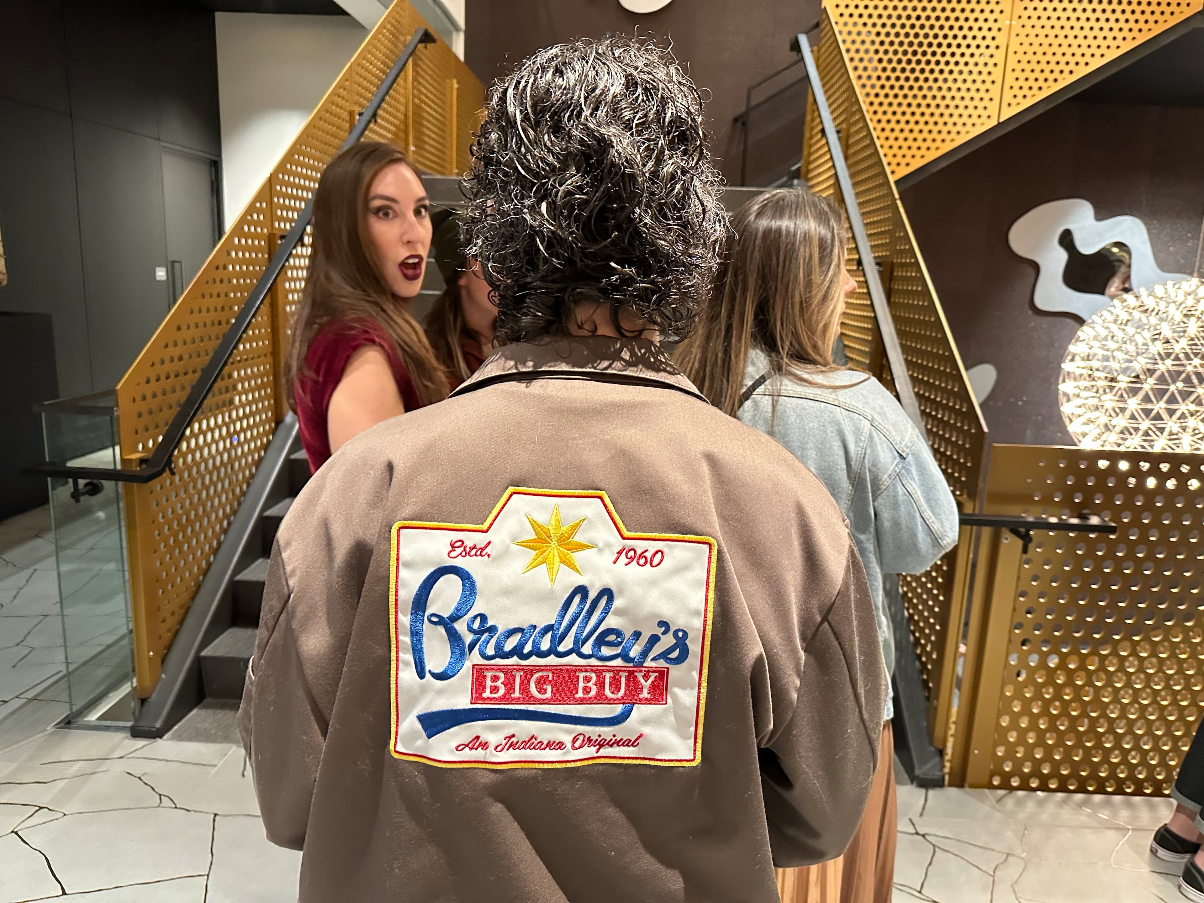 Julia Fredette, who worked in props for "Stranger Things" Season 5, shows off a jacket crew members received of the fictional Bradley's Big Buy at a Netflix-sponsored screening of the Season 5 episode at SCAD in Midtown Atlanta. (Rodney Ho/AJC)