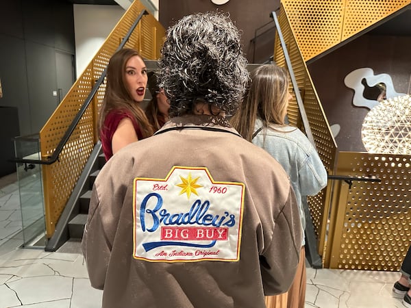 Julia Fredette, who worked in props for "Stranger Things" Season 5, shows off a jacket crew members received of the fictional Bradley's Big Buy at a Netflix-sponsored screening of the Season 5 episode at SCAD in Midtown Atlanta. (Rodney Ho/AJC)