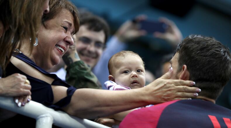 RIO DE JANEIRO, BRAZIL - AUGUST 09: Gold medalist Michael Phelps of the United States celebrates with his mother Deborah Phelps, fiancee Nicole Johnson and son Boomer during the medal ceremony for the Men's 200m Butterfly Final on Day 4 of the Rio 2016 Olympic Games at the Olympic Aquatics Stadium on August 9, 2016 in Rio de Janeiro, Brazil. (Photo by Al Bello/Getty Images)