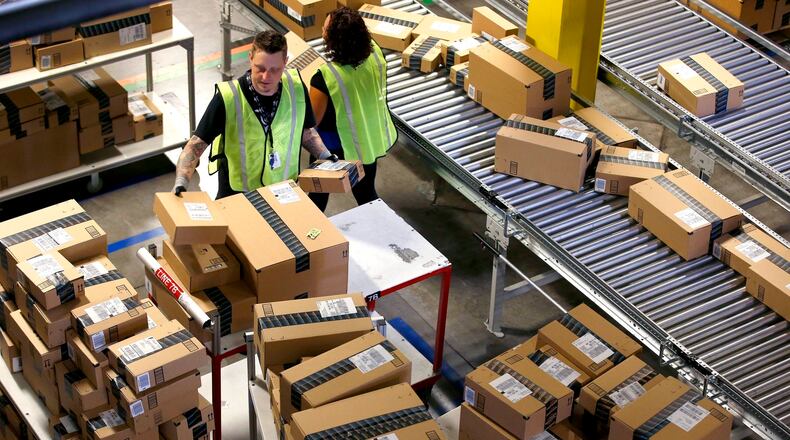 FILE - In this Dec. 2, 2013 file photo, Amazon.com employees organize outbound packages at an Amazon.com Fulfillment Center on "Cyber Monday" the busiest online shopping day of the holiday season, in Phoenix. Buying things online could soon get pricier for many people after the U.S. Supreme Court's decision Monday, Dec. 12, 2016 not to get involved in a case that may lead to states collecting billions in lost sales taxes. The court opted not to hear a challenge to a Colorado law requiring internet retailers to notify customers and the state how much they owe in Colorado taxes. (AP Photo/Ross D. Franklin, file)