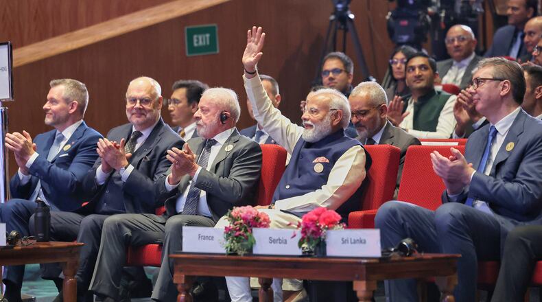 In this photo provided by Indian Prime Minister's Office, lndia's Prime Minister Narendra Modi, center, raises his hand in acknowledgment as other foreign dignitaries clap during the AI Summit in New Delhi, India, Thursday, Feb. 19, 2026. (Indian Prime Minister's Office via AP)