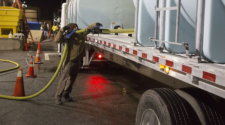 Paul Schuster loaded brine into two 2500 gallon tanks on a flat bed trailer as GDOT crews prepare for distribution on the roads later at a facility in Forest Park on Tuesday morning. The forecast calls for the morning rain to possibly turn into snow as the temperatures fall in the afternoon. (Photo by Phil Skinner)