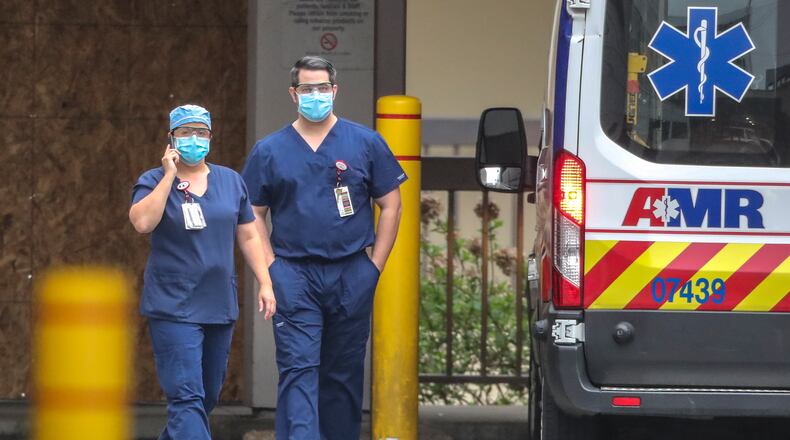 April 8, 2020 Atlanta: Medical workers at WellStar Atlanta Medical Center at 303 Parkway Dr NE in Atlanta walk outside the Emergency Room on Wednesday, April 8, 2020. While EMS agencies say they are doing their best to protect their crews, they say they are not getting resources provided to other health care providers to help respond to the crisis. As a result, concerns are rising to a fever pitch that so many medics will become sick or ordered into isolation that there wonât be enough left to respond to emergency calls. In Georgia, two dozen state EMS workers have been quarantined just since Tuesday. In the past few weeks, some ambulance providers say that dozens of medics have been quarantined but only a handful have tested positive for the disease, including some in south Fulton. But other paramedics who contacted the AJC said they had also contracted the infection but did not want to be identified for fear of losing their jobs. Gov. Brian Kemp said Wednesday he would extend Georgiaâs public health emergency through May 13, granting him more time to use extraordinary powers to suspend laws and impose other restrictions to contain the coronavirus pandemic. The extension prolongs the governorâs authority to take âdirectâ control of civil staffers, restrict travel, limit public gatherings and institute a range of other measures to combat the disease. JOHN SPINK/JSPINK@AJC.COM