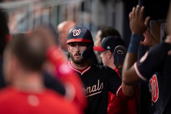 Washington Nationals' Dylan Crews (3) celebrates in the dugout after scoring in the seventh inning of a baseball game against the Atlanta Braves Wednesday, May 14, 2025 in Atlanta. (AP Photo/Kathryn Skeean)