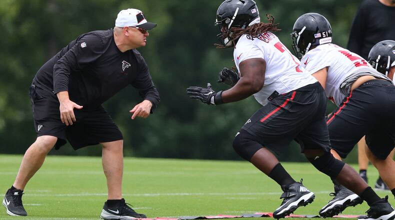 Down in the trenches: Offensive line coach Chris Morgan gets in some work with guard James Carpenter during Wednesday's minicamp practice in Flowery Branch. (Curtis Compton/ccompton@ajc.com).