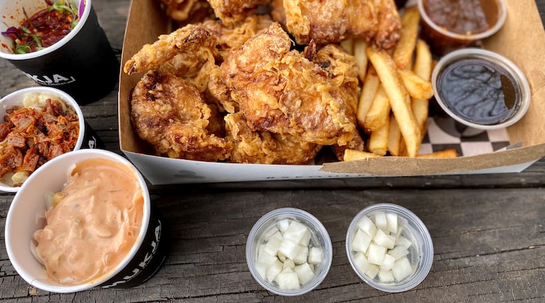 This takeout order from Mukja Korean Fried Chicken includes a whole fried chicken with sauces, fries, pickled radish and sides. Wendell Brock for The Atlanta Journal-Constitution