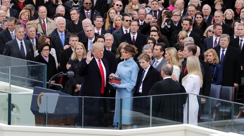 WASHINGTON, DC - JANUARY 20: Supreme Court Justice John Roberts (R) administers the oath of office to U.S. President Donald Trump (L) as his wife Melania Trump holds the Bible and his son Barron Trump looks on, on the West Front of the U.S. Capitol on January 20, 2017 in Washington, DC. In today's inauguration ceremony Donald J. Trump becomes the 45th president of the United States. (Photo by Chip Somodevilla/Getty Images)