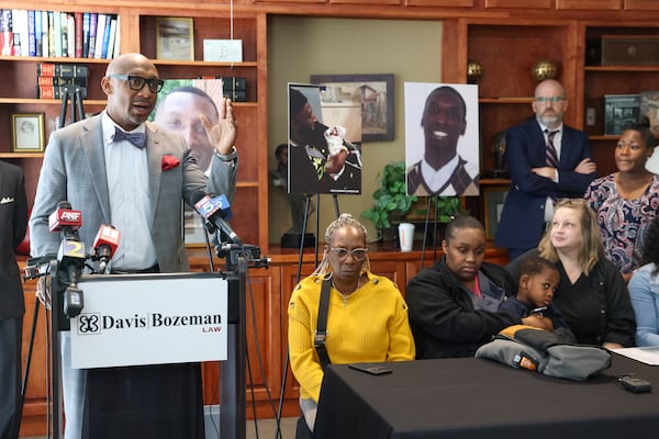 Attorney Mawuli Davis, left, speaks during a press conference about the late Dino Walker in front of his family  at the office of Davis Bozeman Johnson Law, Thursday, September 21, 2023, in Decatur, Ga. Walker was a Fulton inmate who was stabbed to death at the Fulton County Jail in 2022. (Jason Getz / Jason.Getz@ajc.com)