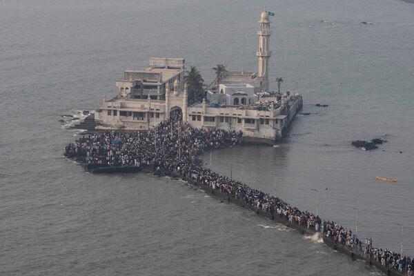 People arrive to offer prayers at Haji Ali Dargah, a Muslim shrine by the Arabian Sea coast in Mumbai, India, Wednesday, April 2, 2025. (AP Photo/Rafiq Maqbool)