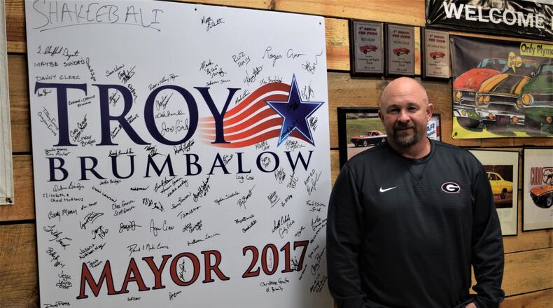 City of Cumming Mayor-elect Troy Brumbalow at his home with one of his campaign signs signed by friends and volunteers on election night as they celebrated his upset over long-time incumbent H. Ford Gravitt. Marty Farrell for the AJC